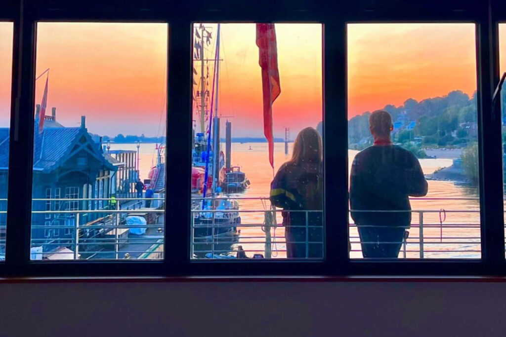 Lieger Oevelgönne, zwei Menschen blicken auf den Sonnenuntergang